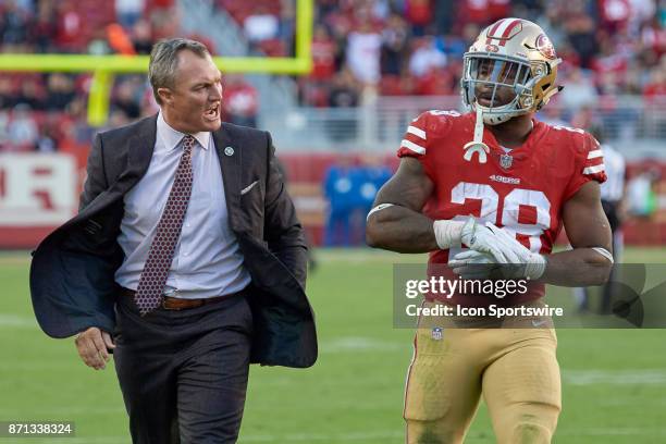 San Francisco 49ers General Manager John Lynch walks off the field as he talks with San Francisco 49ers running back Carlos Hyde who was ejected...