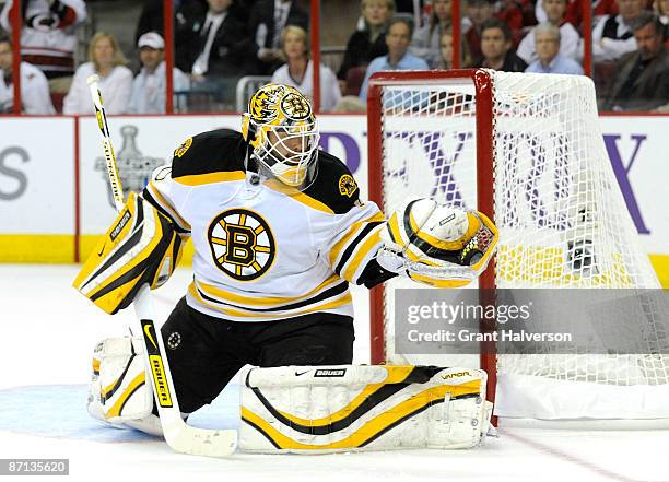Goalkeeper Tim Thomas of the Boston Bruins makes a glove save on a shot by Chad LaRose of the Carolina Hurricanes in the second period during Game...