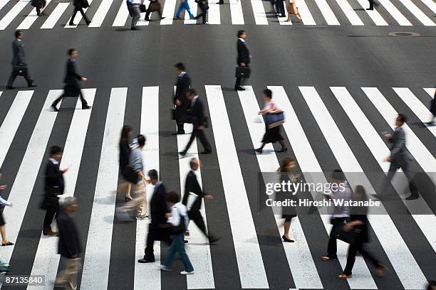 people who cross a pedestrian crossing - strisce pedonali foto e immagini stock