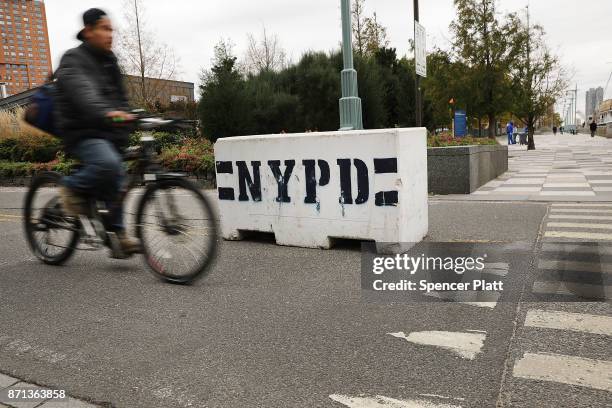 Cyclist rides past new police barriers near the location where terrorist Sayfullo Saipov entered a Manhattan bike path and went on a rampage with a...