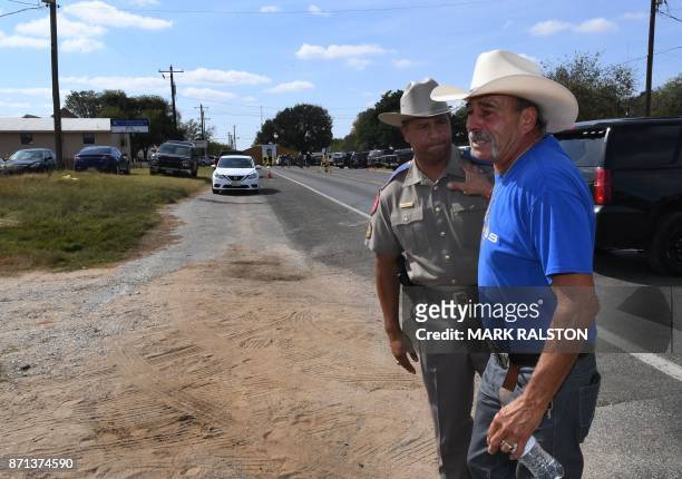 Rene Morino hugs a state trooper at a memorial outside the First Baptist Church, after a mass shooting that killed 26 people in Sutherland Springs,...