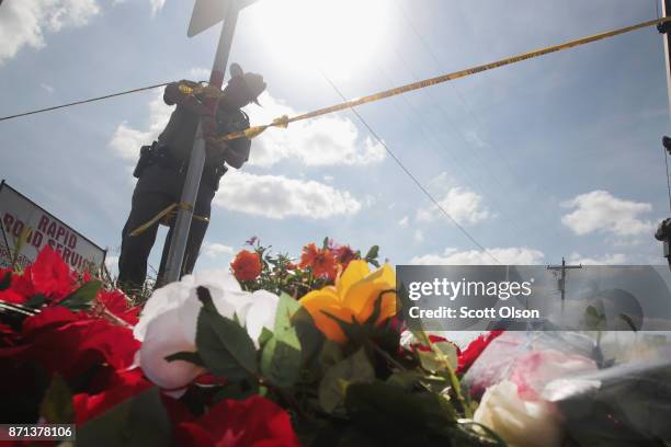 Police officer ties off crime scene tape near a small memorial close to the First Baptist Church of Sutherland Springs on November 7, 2017 in...