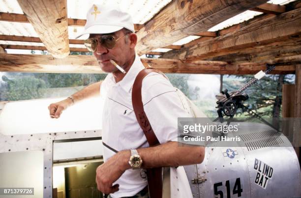 Hunter Thompson aka Hunter S Thompson aka Gonzo Journalist at his ranch standing next to his Link Trainer with a pistol on October 12, 1990 in Woody...
