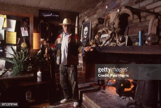 Hunter Thompson aka Hunter S Thompson aka Gonzo Journalist at his ranch standing next to his fireplace after adding logs to burn on October 12, 1990...