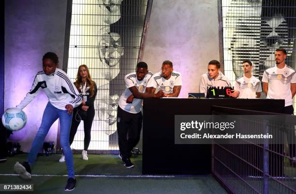 German national football team players look on as a fan plays with a ball at the presentation of the 2018 FIFA World Cup Russia Adidas jersey at The...