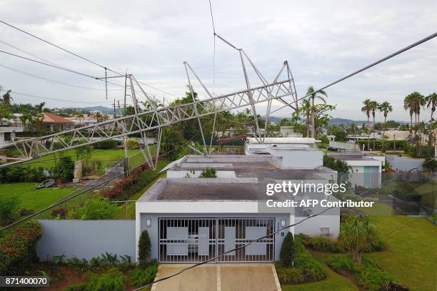 Power line tower downed by the passing of Hurricane Maria lies on top of a house in San Juan, Puerto Rico on November 7, 2017. The Center for Puerto...