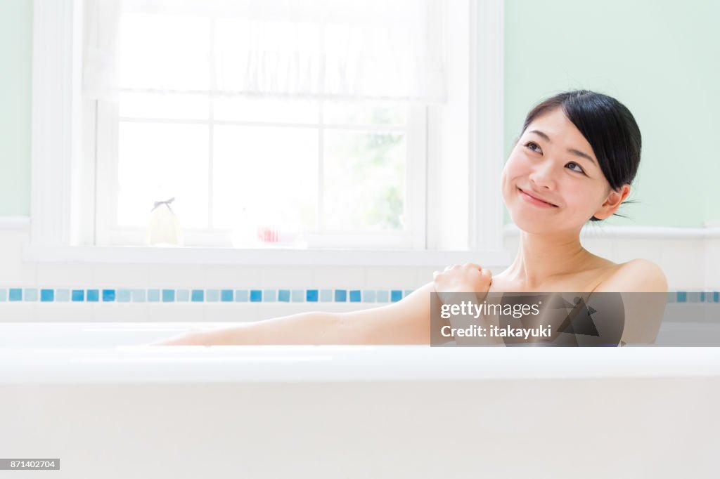 Jonge Aziatische vrouw in badkamer