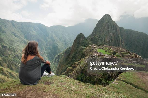 young woman on the cliff in the ancient city of machu picchu, peru. - machu pichu stock pictures, royalty-free photos & images