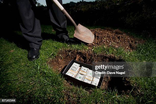 man buring casn in a box in the ground - digging hole stock pictures, royalty-free photos & images