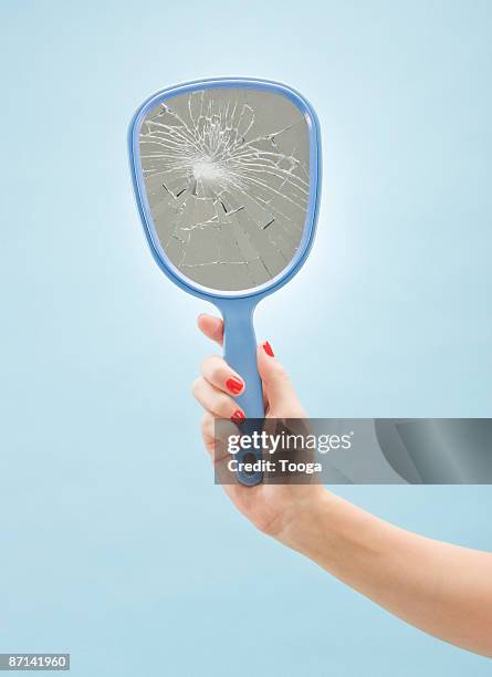 woman holding broken mirror - hand mirror stock pictures, royalty-free photos & images