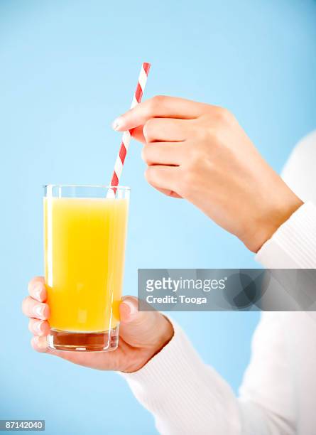 woman drinking orange juice - rietje stockfoto's en -beelden