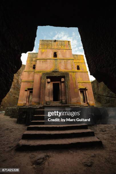 the rock hewn bet giyorgis framed by a passageway entering the courtyard, lalibela, ethiopia - lalibela foto e immagini stock