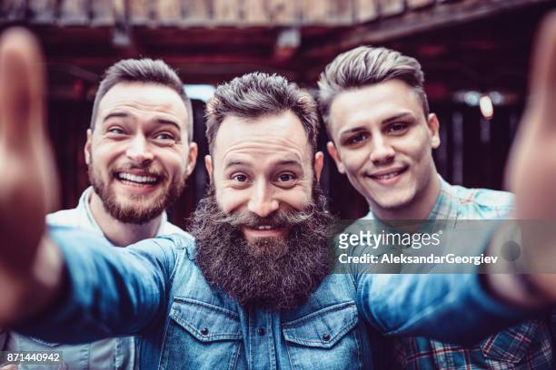 pazzi ragazzi al pub che bevono birra e si fanno selfie - barba peluria del viso foto e immagini stock