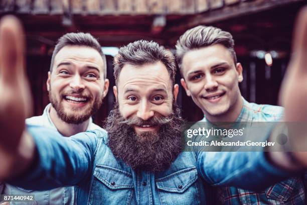 crazy guys at pub drinking beer and taking selfie - beard imagens e fotografias de stock