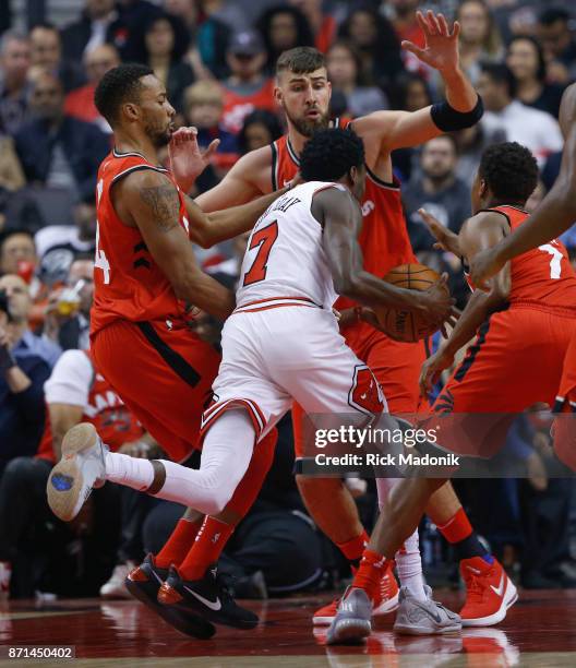 Chicago Bulls guard Justin Holiday runs into a crowd of Toronto Raptors forward Norman Powell , Toronto Raptors center Jonas Valanciunas and Toronto...