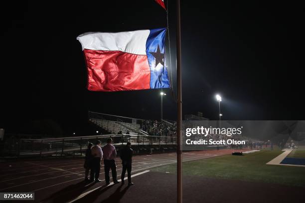 Texas flag flies at half mast during a prayer services at the La Vernia High School Football stadium to grieve the 26 victims killed at the First...