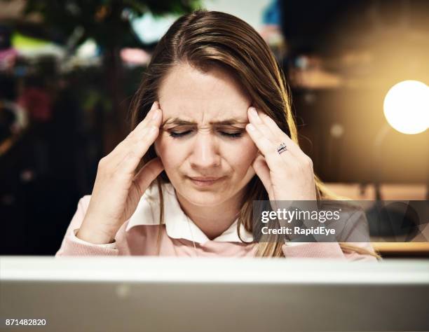oficinista de mujer rubia frota templos, cansados y headachey - sien fotografías e imágenes de stock