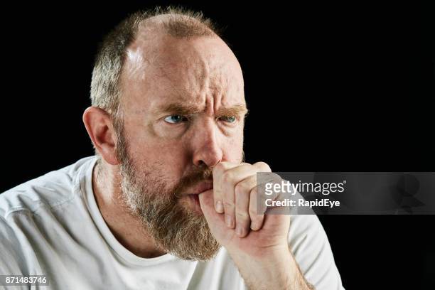 sucking his thumb, a mature, bearded man glowers threateningly - suck stock pictures, royalty-free photos & images