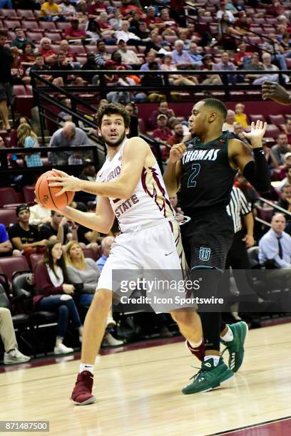 Wyatt Wilkes forward Florida State University Seminoles attempts to pass the basketball against Javoris Cooks guard Thomas University Night Hawks in...