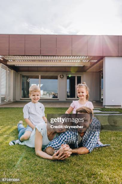 familia feliz disfrutando sobre la hierba en el balcón del penthouse. - penthouse girl fotografías e imágenes de stock