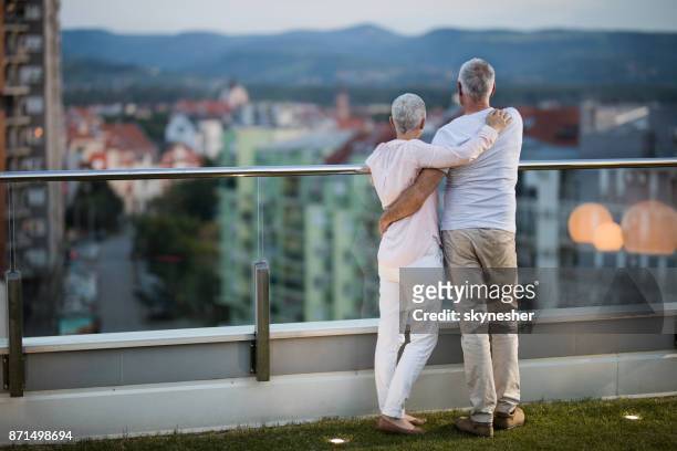 從閣樓陽臺的角度來看, 被擁抱的年長夫婦的看法。 - women of penthouse 個照片及圖片檔