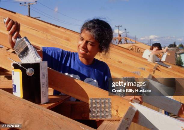 woman doing volunteer painting for 'habitats for humanity' - hábitat para la humanidad fotografías e imágenes de stock