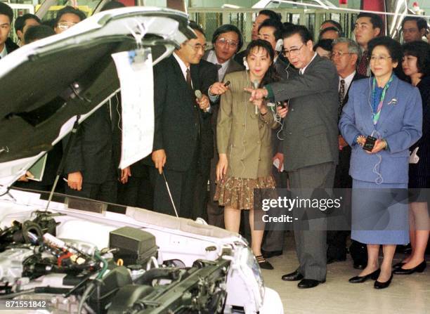 Chinese Prime Minister Li Peng and his wife Zhu Lin inspect an assembly line of passenger cars when they visit the headquarters of Japanese leading...