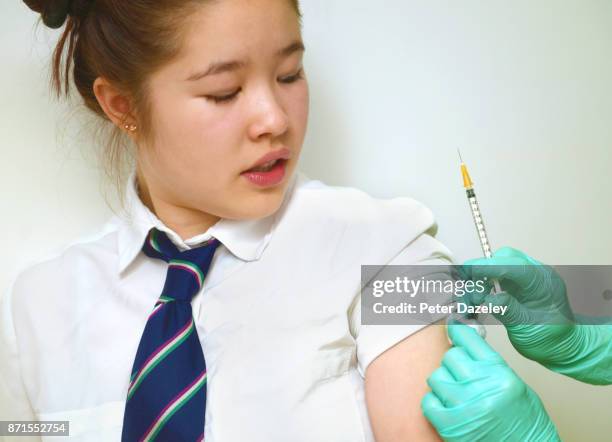 schoolgirl getting vaccinated - vph fotografías e imágenes de stock