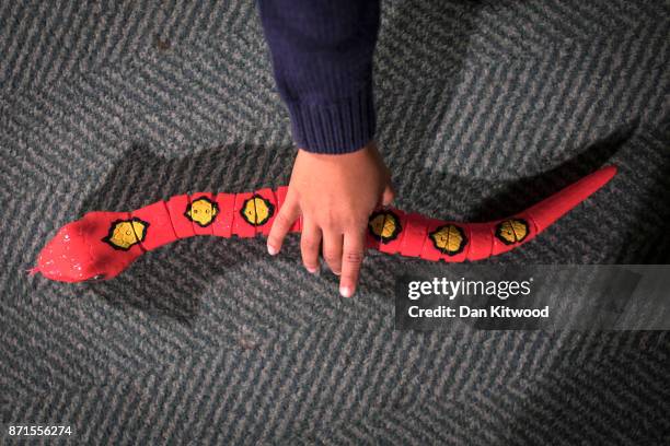 Child plays with a 'Robo Alive, Snake' during a media event announcing the top 12 toys for christmas at St Mary's Church in Marylebone on November 8,...