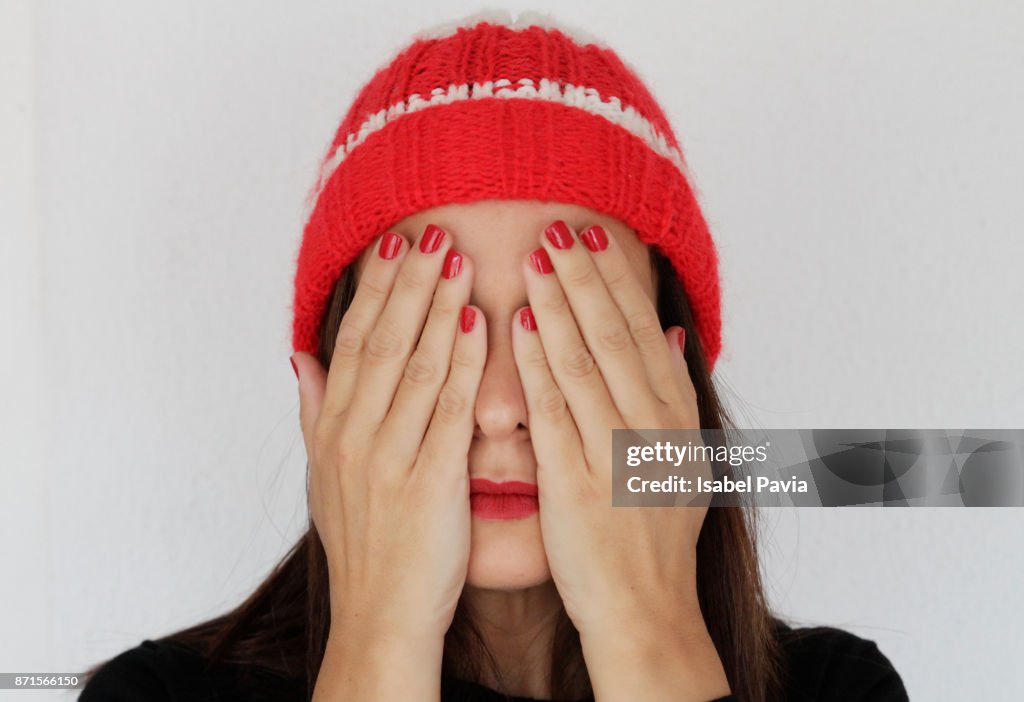 Young woman covering face, close-up