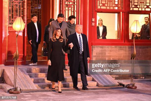 President Donald Trump walks with First Lady Melania Trump as they tour the Forbidden City with China's President Xi Jinping and his wife Peng Liyuan...