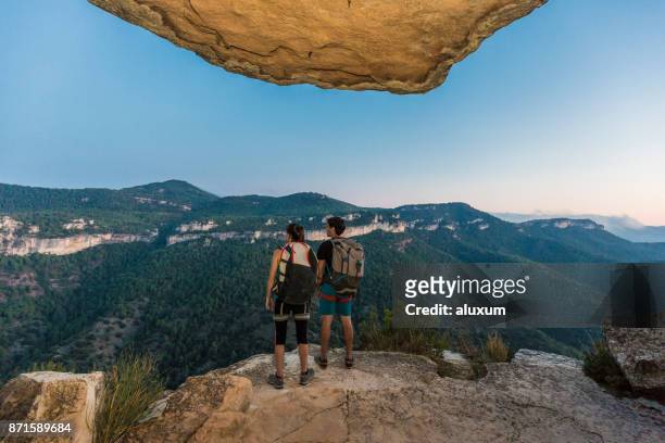 couple of rock climbers looking at landscape at sunset in siurana catalonia spain - tarragona stock pictures, royalty-free photos & images