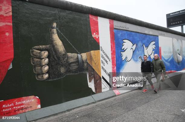 People visit the East Side Gallery on the 27th anniversary of the fall of the Berlin Wall in Berlin, Germany on November 5, 2017. Brandenburg Gate is...