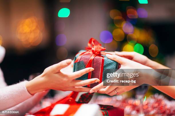 hands giving gift close-up - christmas gift exchange stock pictures, royalty-free photos & images