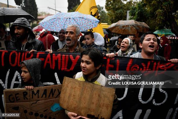 Refugees protest outside the German embassy in Athens under pouring rain, on November 8 to demand a faster family reunification process in Germany. -...