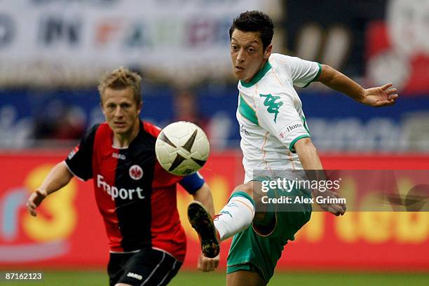 Mesut Oezil of Bremen controls the ball ahead of Christoph Spycher of Frankfurt during the Bundesliga match between Eintracht Frankfurt and Werder...