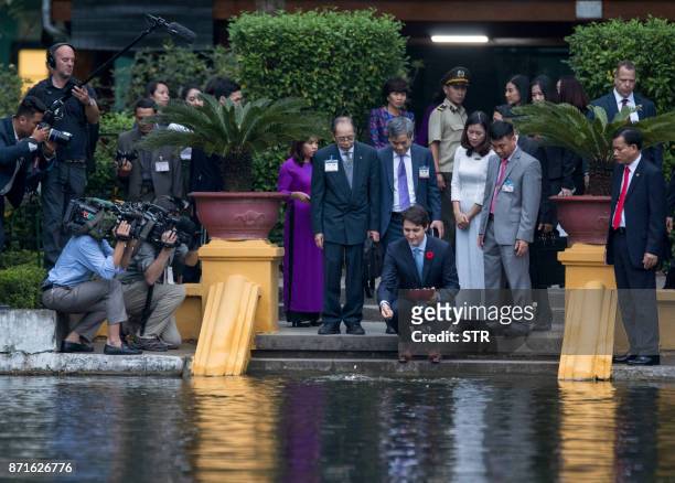 Canada's Prime Minister Justin Trudeau feeds fish at the former residence of late president Ho Chi Minh inside the presidential palace ground in...