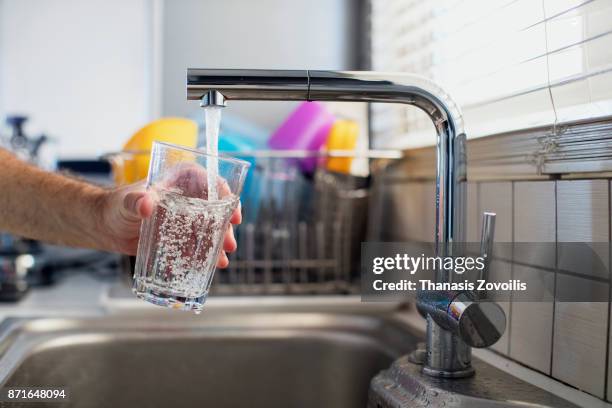 man holding a glass of water - faucet fotografías e imágenes de stock