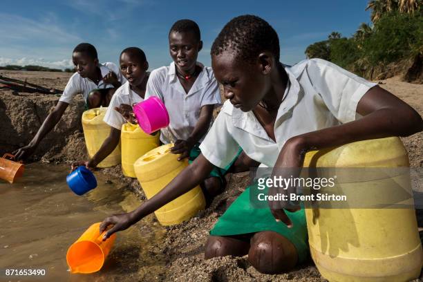 Girls from Kalokol Girls Primary school collect water from a dry river bed as their school does do not have access to running water. The girls take...