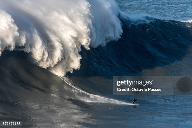 Britan big wave surfer Andrew Cotton drops a wave during a surf session at Praia do Norte on November 8, 2017 in Nazare, Portugal. Cotton suffered a...