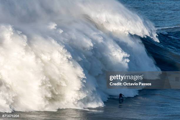 Britan big wave surfer Andrew Cotton drops a wave during a surf session at Praia do Norte on November 8, 2017 in Nazare, Portugal. Cotton suffered a...