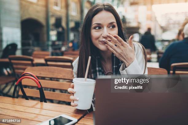 refreshing in a sidewalk cafe - woman embarrassed phone stock pictures, royalty-free photos & images
