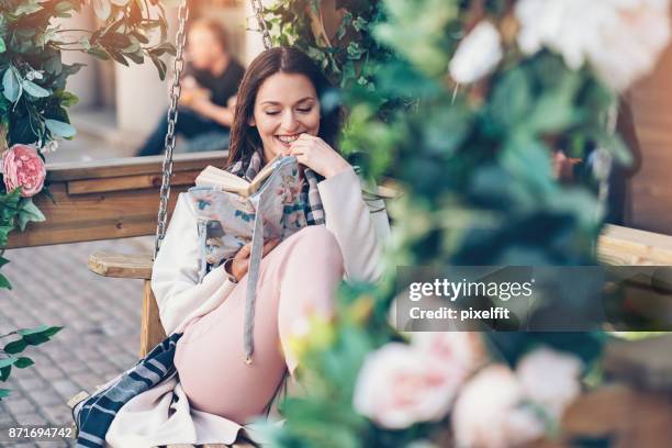 disfrutando de un buen libro al aire libre en el jardín - mujer leyendo libro en el parque fotografías e imágenes de stock