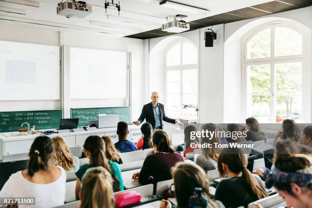 university professor addressing his pupils during lecture - university photos et images de collection