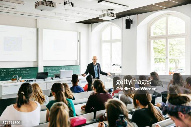 university professor addressing his pupils during lecture - universiteit stockfoto's en -beelden