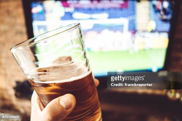 man kijken naar de voetbal wedstrijd op de tv - ball on a table stockfoto's en -beelden