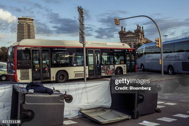 Overturned garbage bins lie on a city highway as protesters blockade city roads during a regional strike called by pro-independence union in...