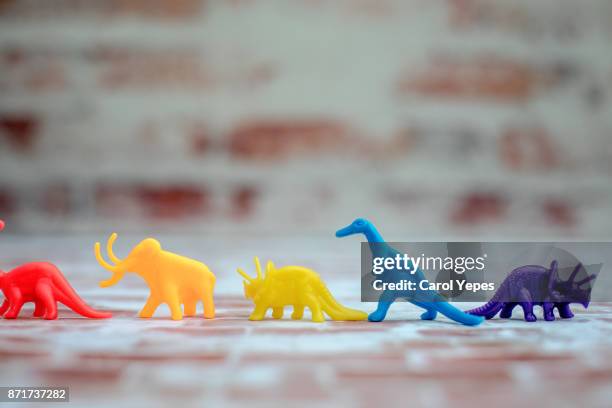 colorful dinosaurs in a row - tyrannosaur stock pictures, royalty-free photos & images