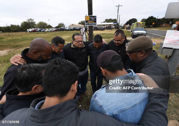 Group of 12 pastors from local churches, pray beside a memorial service for victims of the mass shooting that killed 26 people in Sutherland Springs,...