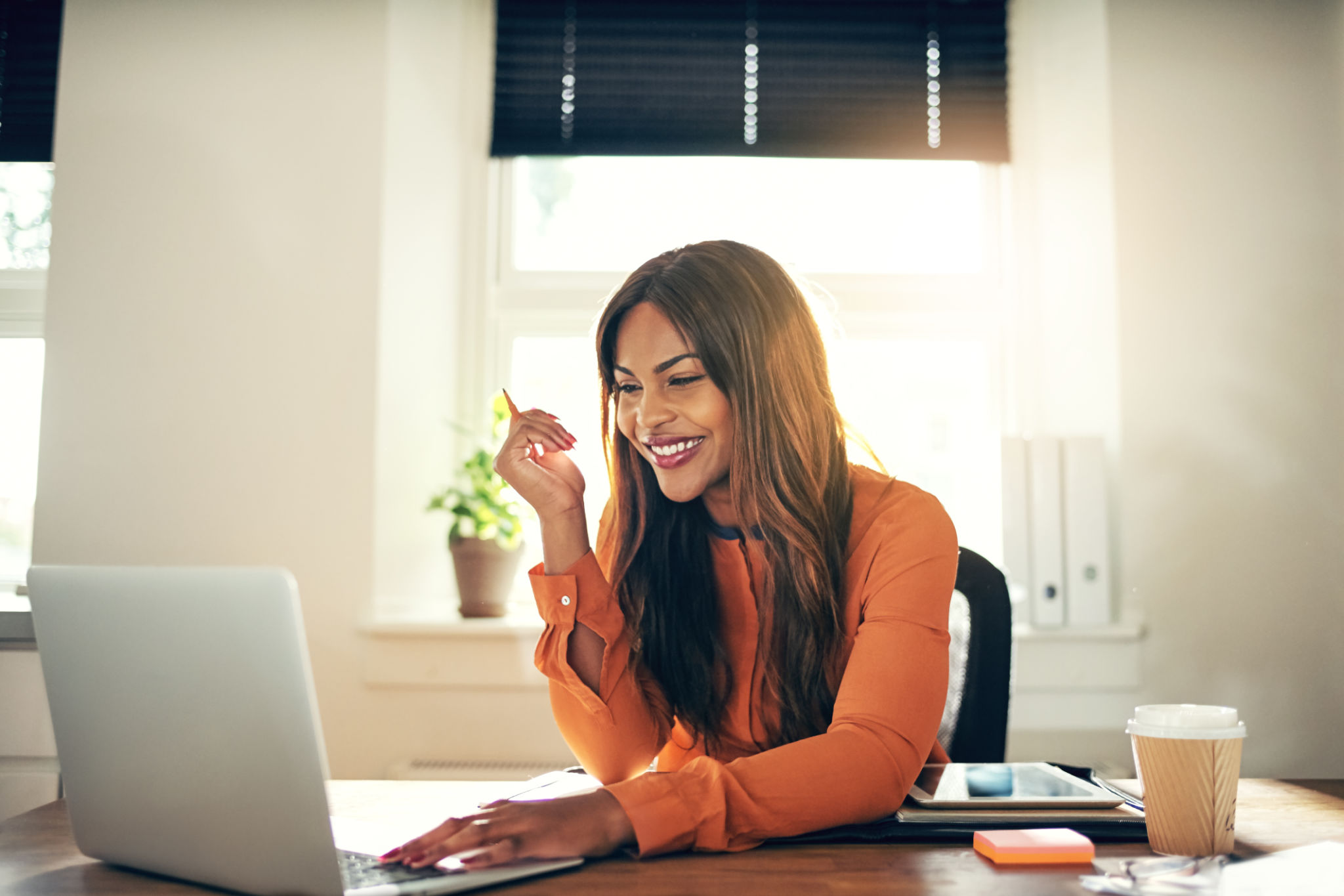 Smiling young female entrepreneur working on a laptop at home Smiling young female entrepreneur working on a laptop at home